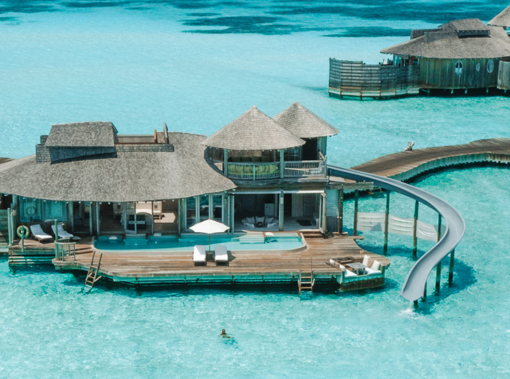 Overwater villa with a waterslide into the lagoon.