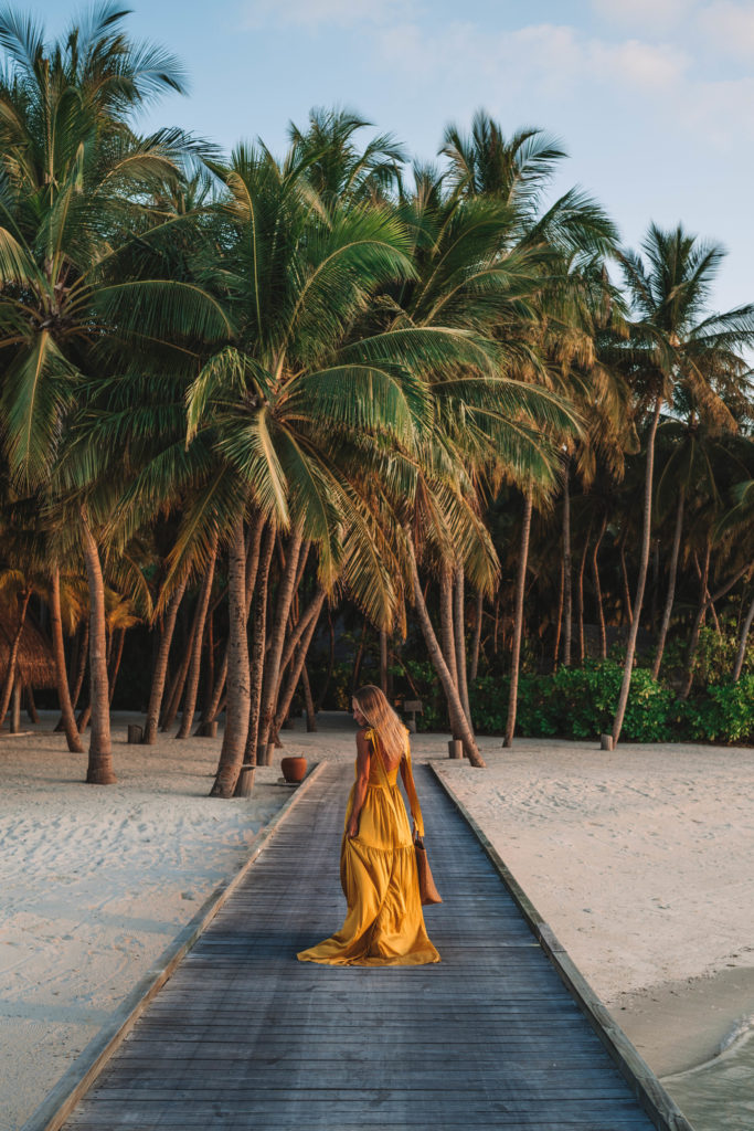 Woman walking to dinner in yellow silk dress.