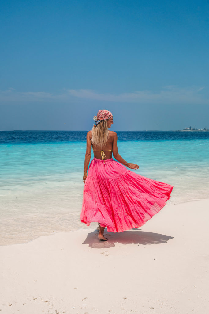 Salty Luxe in a bright pink skirt on the beach at Como Cocoa