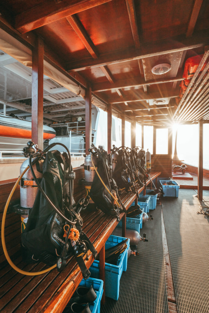 Diving equipment set up on a wooden boat, in preparation for diving activities.