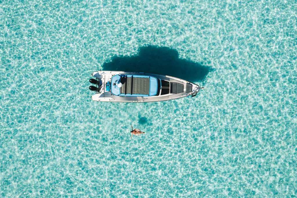 drone shot of sarah floating next to a boat