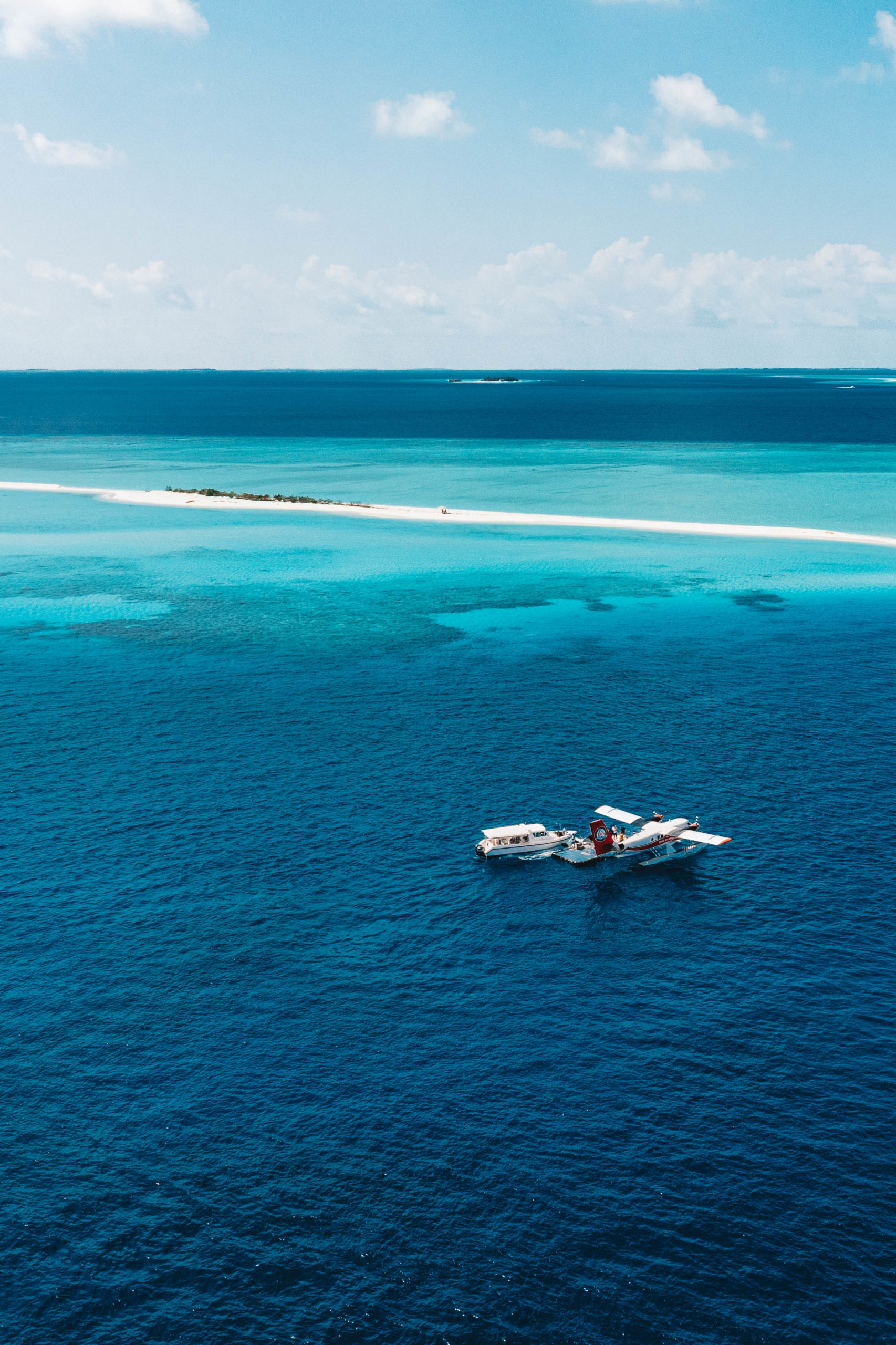 Drone shot of maldives island, boat and sea plane
