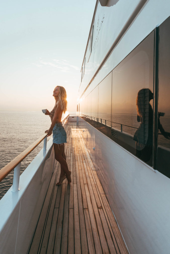 Sarah at sunrise on Four Seasons Cruise Boat drinking coffee