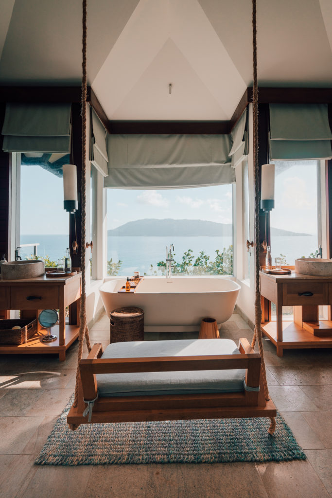 Luxury bathroom with swinging chair and bathtub, Six Senses Seychelles.