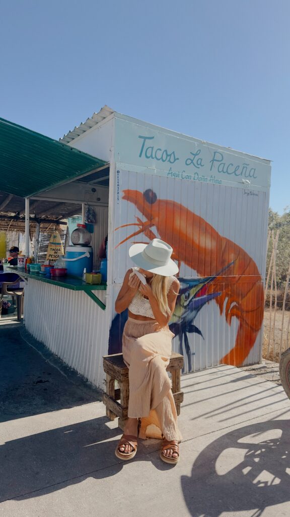 Woman eating a taco from a street vendor.