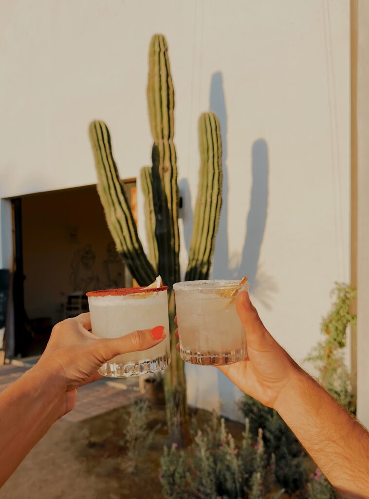 Two margarita cocktails clinking together