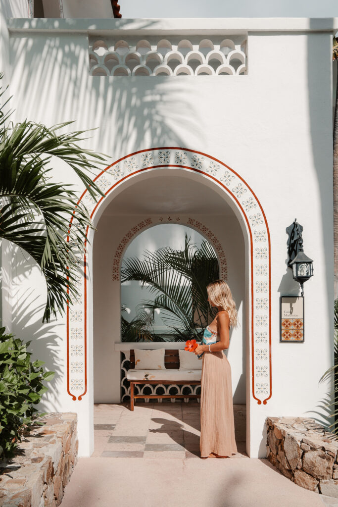 Woman in archway with a flower at Palmilla Hotel