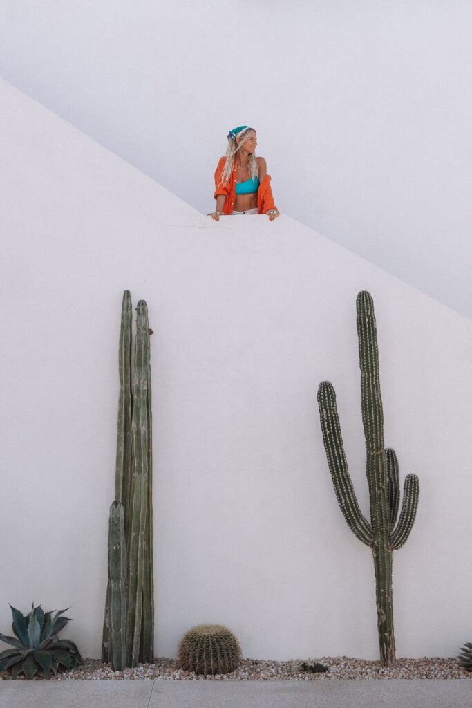 Woman on balcony with white walls and cactus plantings at San Christobal Hotel 