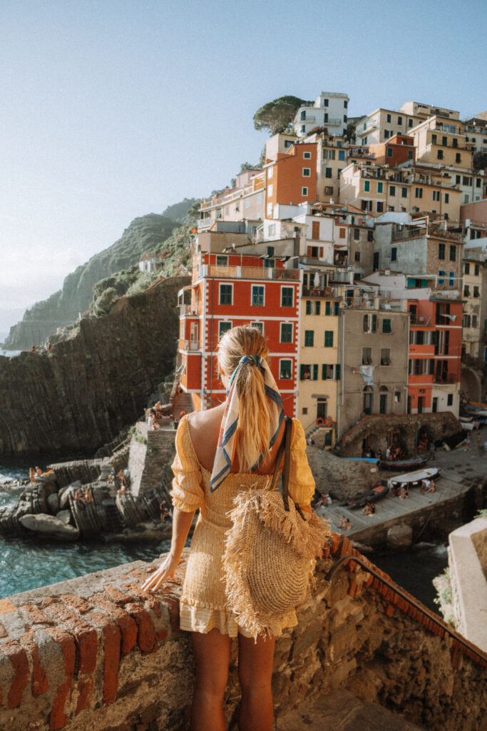 Woman looking out over the harbour of Riomaggiore.