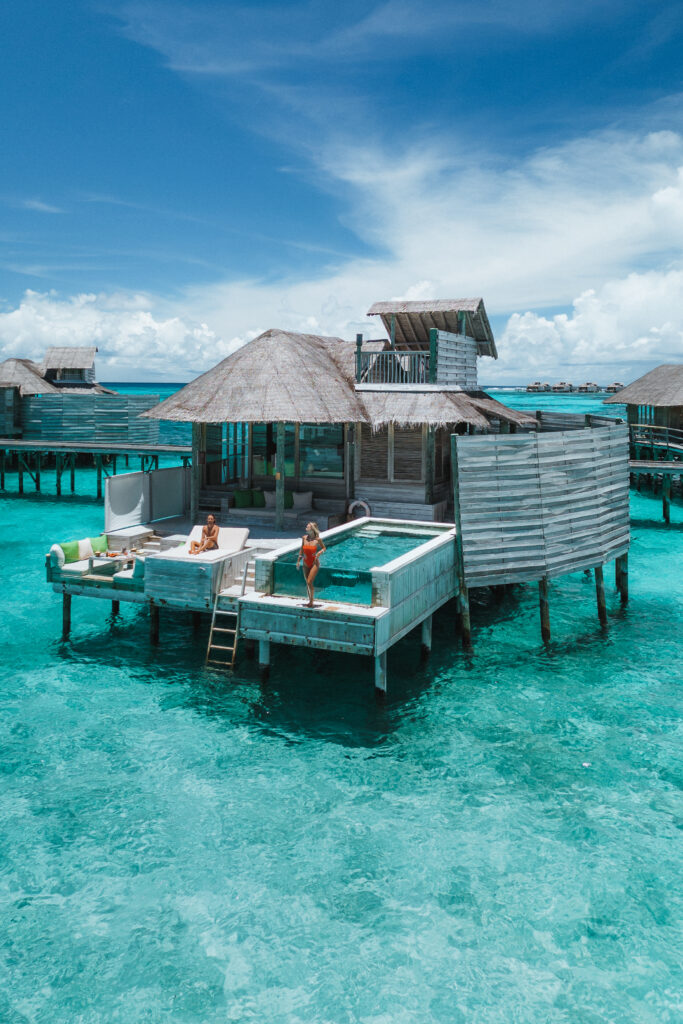 Couple looking out to sea from their overwater villa.