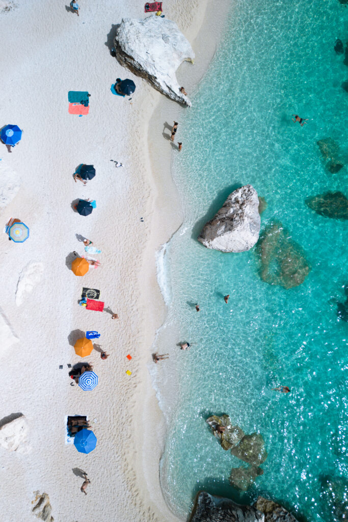 Aerial view of beach umbrellas and bathers at a beach.