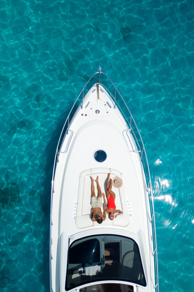Couple laying at front of a luxury charter boat.