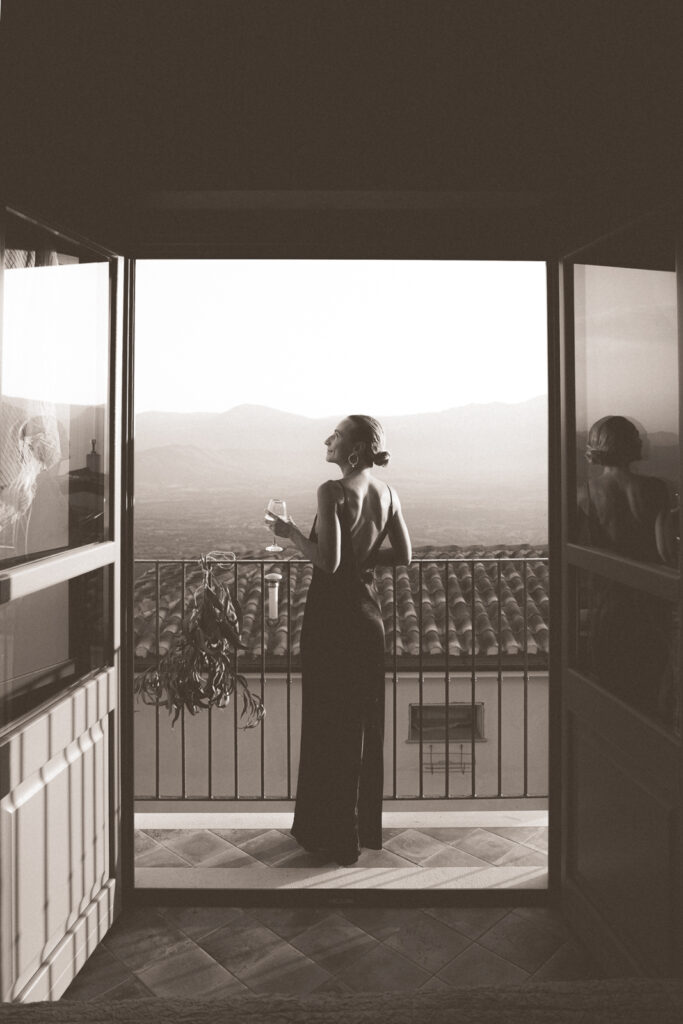 Woman holding glass of wine on a balcony in Baunei.