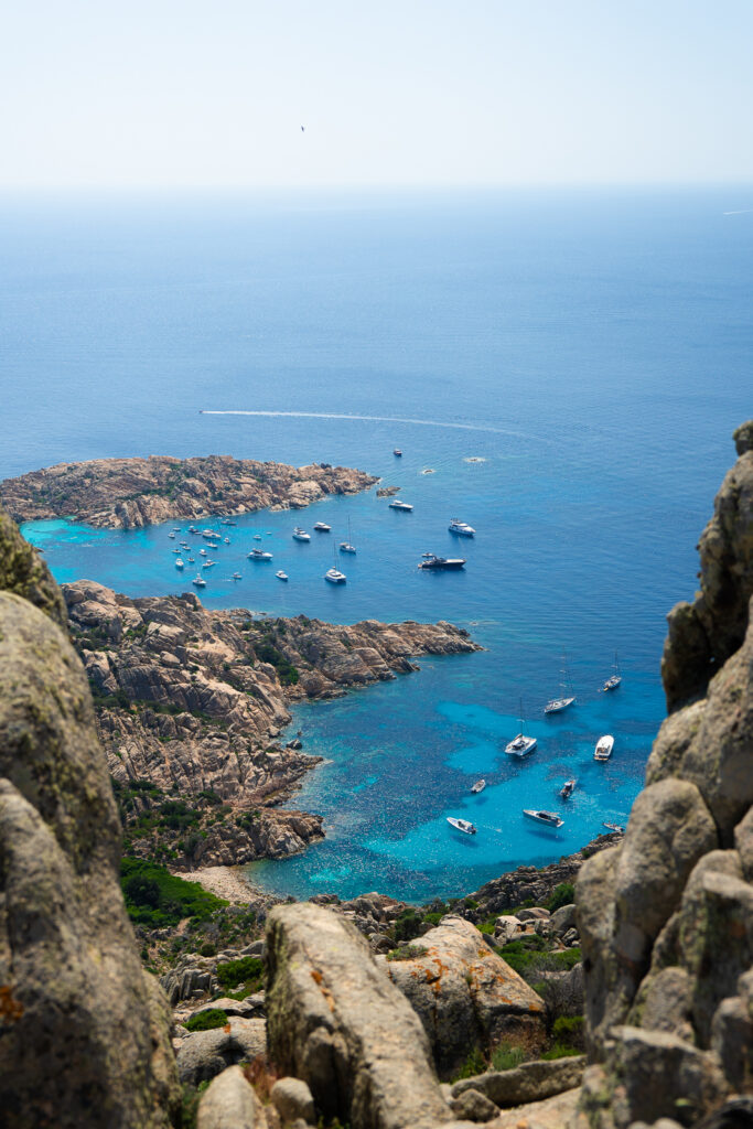 The bay of Cala Coticcio beach, with several boats anchored offshore.