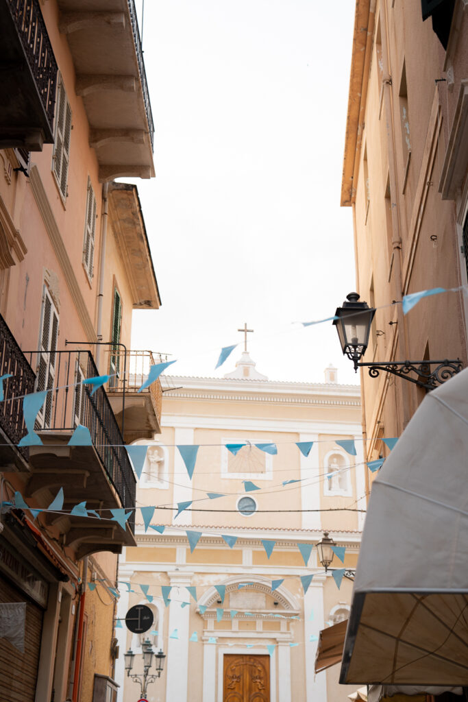 Flags strung between buildings of a narrow street in La Maddalena.