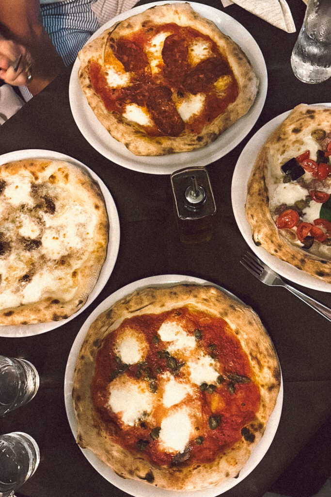 Four pizzas placed on a table at Civico 49 restaurant.