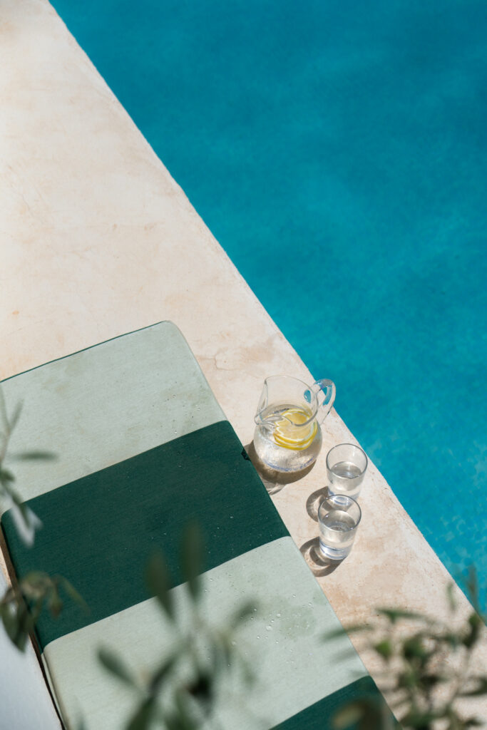 Glass and pitcher of water next to the pool at Morvedra Nou