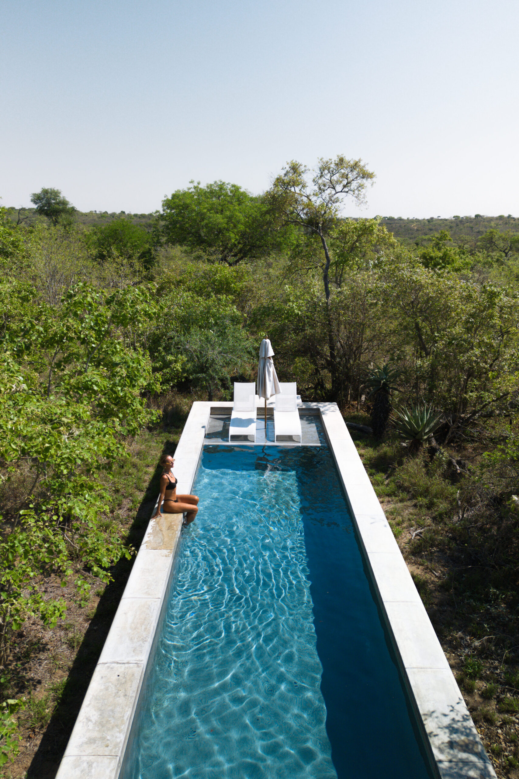 Salty luxe sitting on the edge of the private lap pool at the farmhouse at farmstead royal malewane