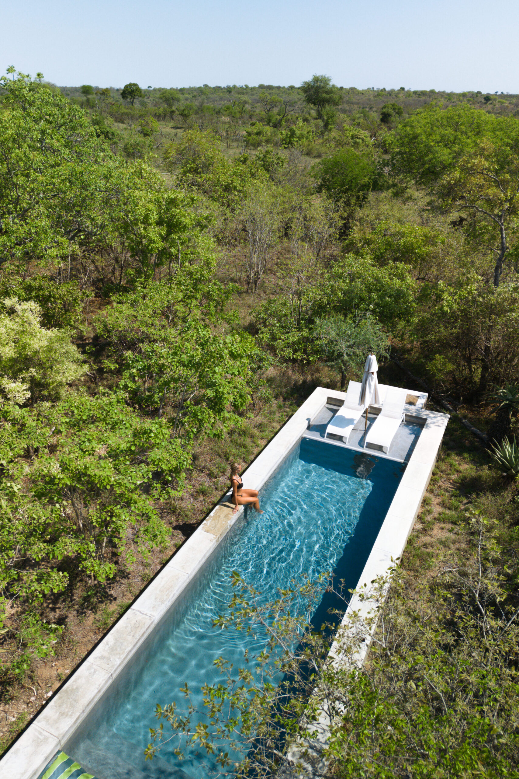 salty luxe sitting on the edge of the pool at farmstead farmhouse royal malewane