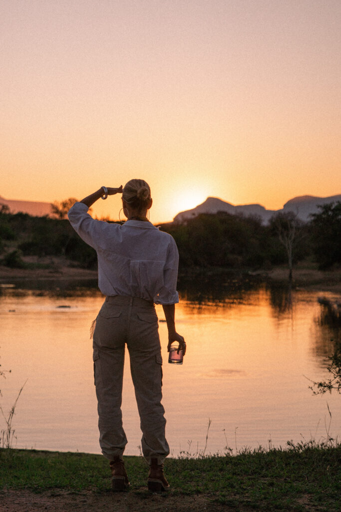 salty luxe watching sunset at a watering hole in royal malewane