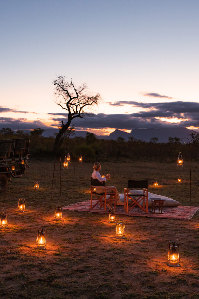 salty luxe as  the sun sets at royal malewane with lanterns lit up around her