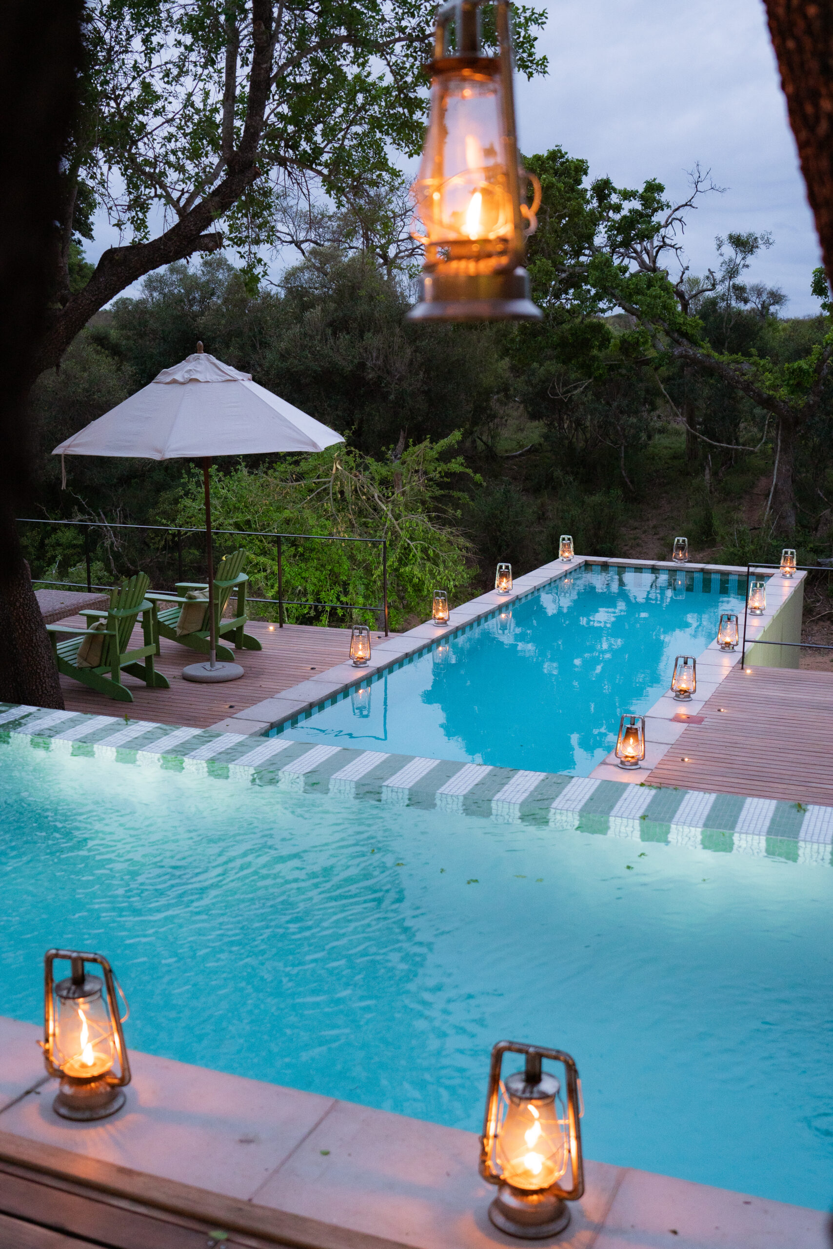 private pool at africa house royal malewane with lanterns around the edge of the pool