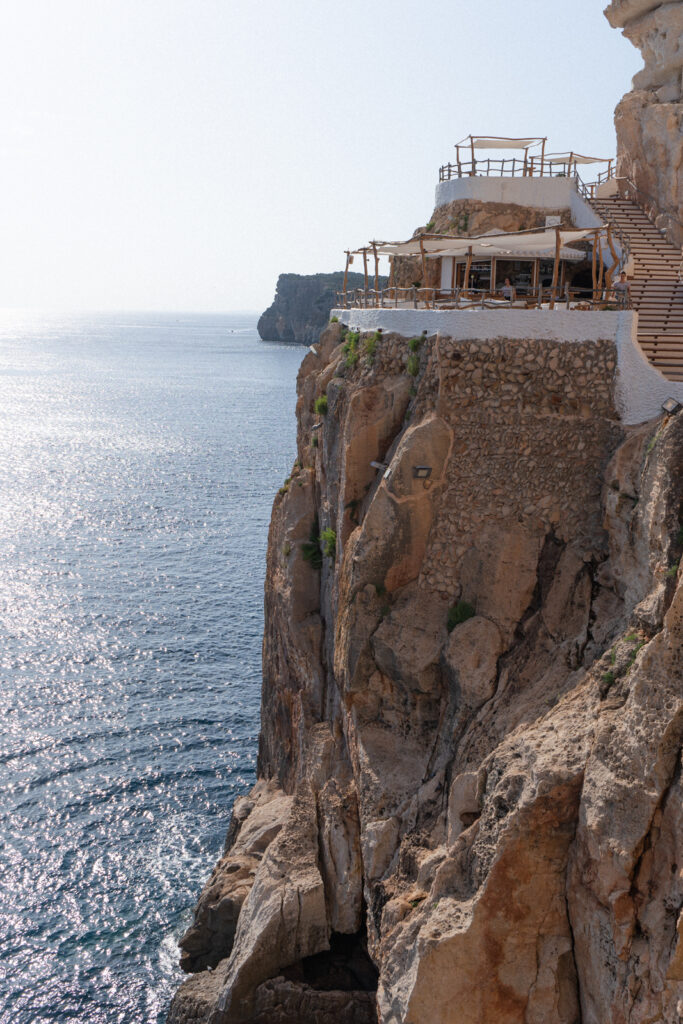 Cova d'en Xoroi in Menorca stands on the edge of a cliff overlooking the water