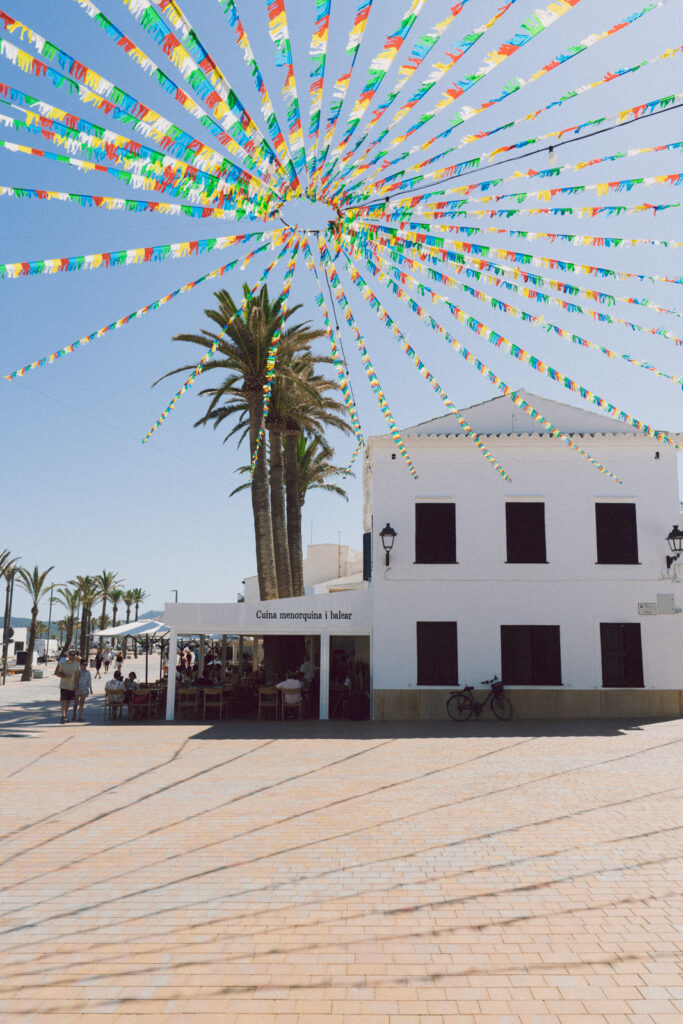 Buildings and colorful flags in Fornells in Menorca