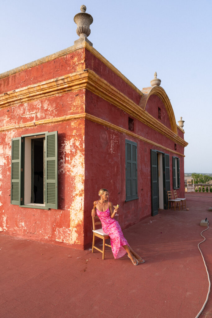 Woman in a pink dress drinking a cocktail at Nonna Bazaar Menorca