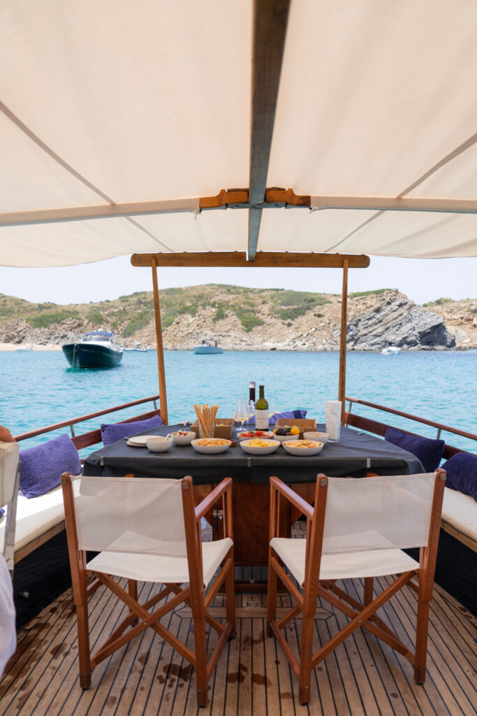 A table with food on a traditional wooden boat tour in Menorca