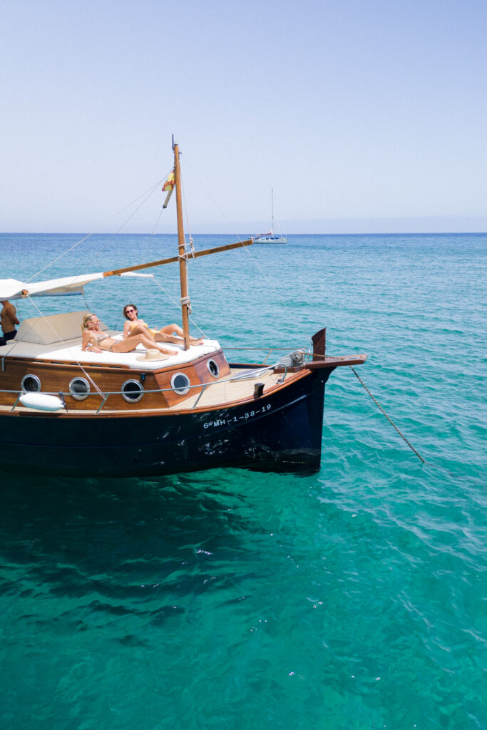 two woman sunbathing on a boat tour in menorca