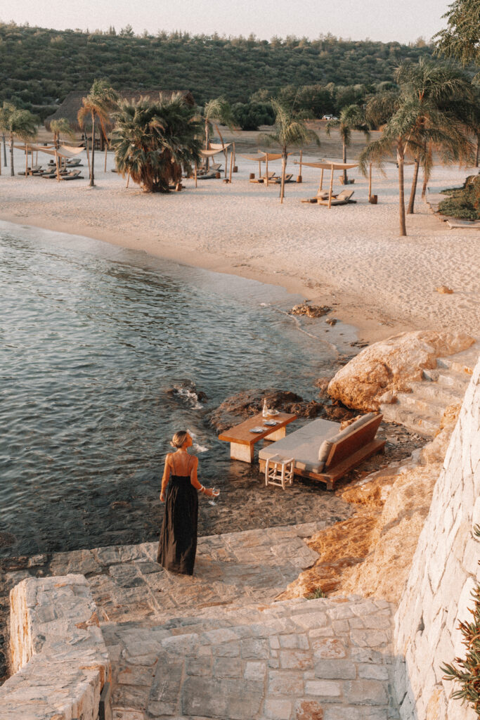 woman in a black dress walking down a stone staircase to the beach at Six Senses Kaplankaya