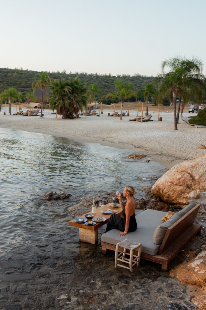 salty luxe eating at a table in the water at Six Senses Kaplankaya