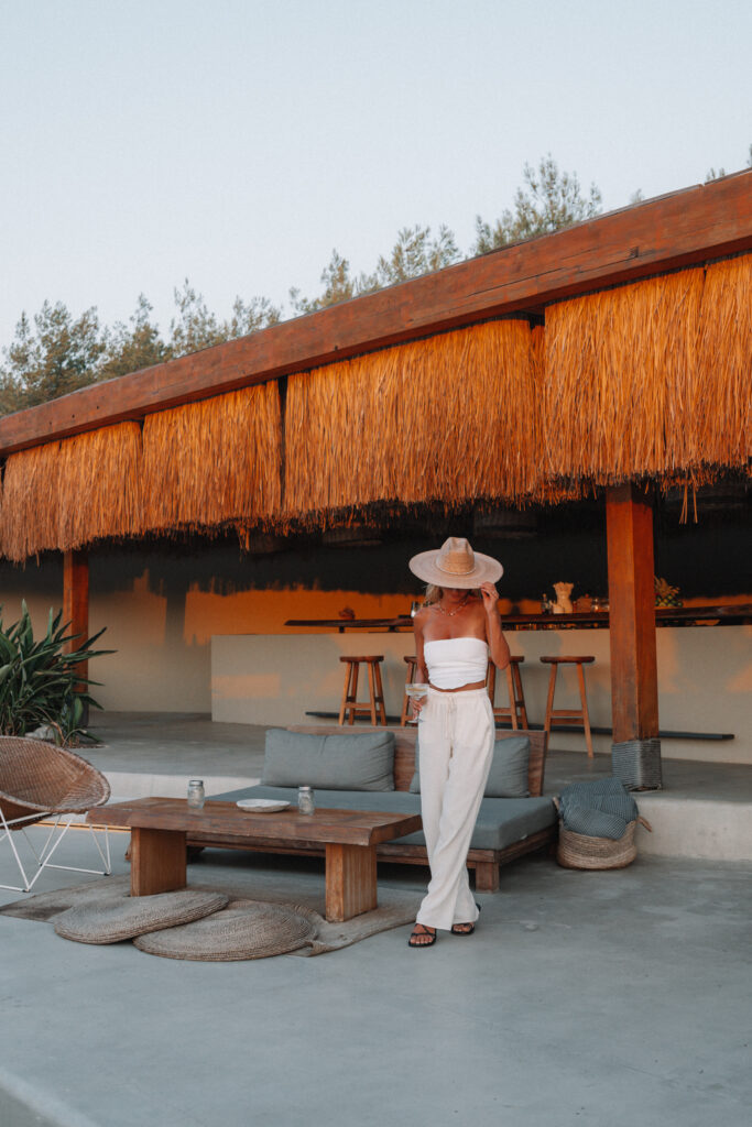 a woman in a white shirt and pants at the bar at Six Senses Kaplankaya