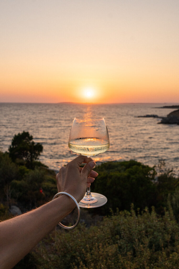 a glass of wine in front of the sunset