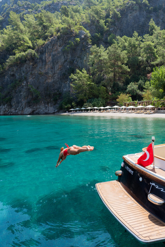 salty luxe jumping off a boat at yazz collective fethiye on the turkish riviera