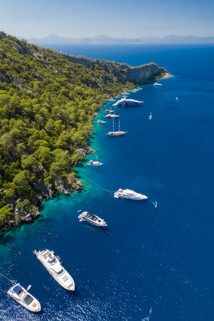 drone photo of tour boats and yachts on the coast of the turkish riviera