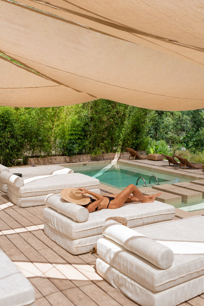 woman in a black bikini laying out by the pool at yazz collective fethiye