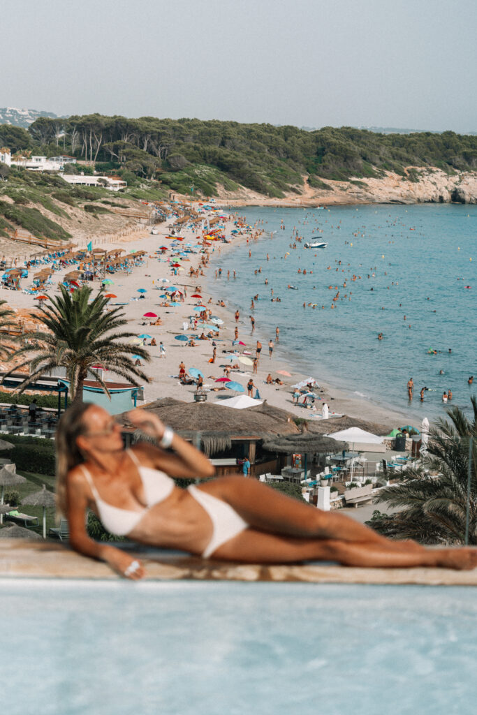 a woman in a white bikini next to the pool at villa le blanc menorca