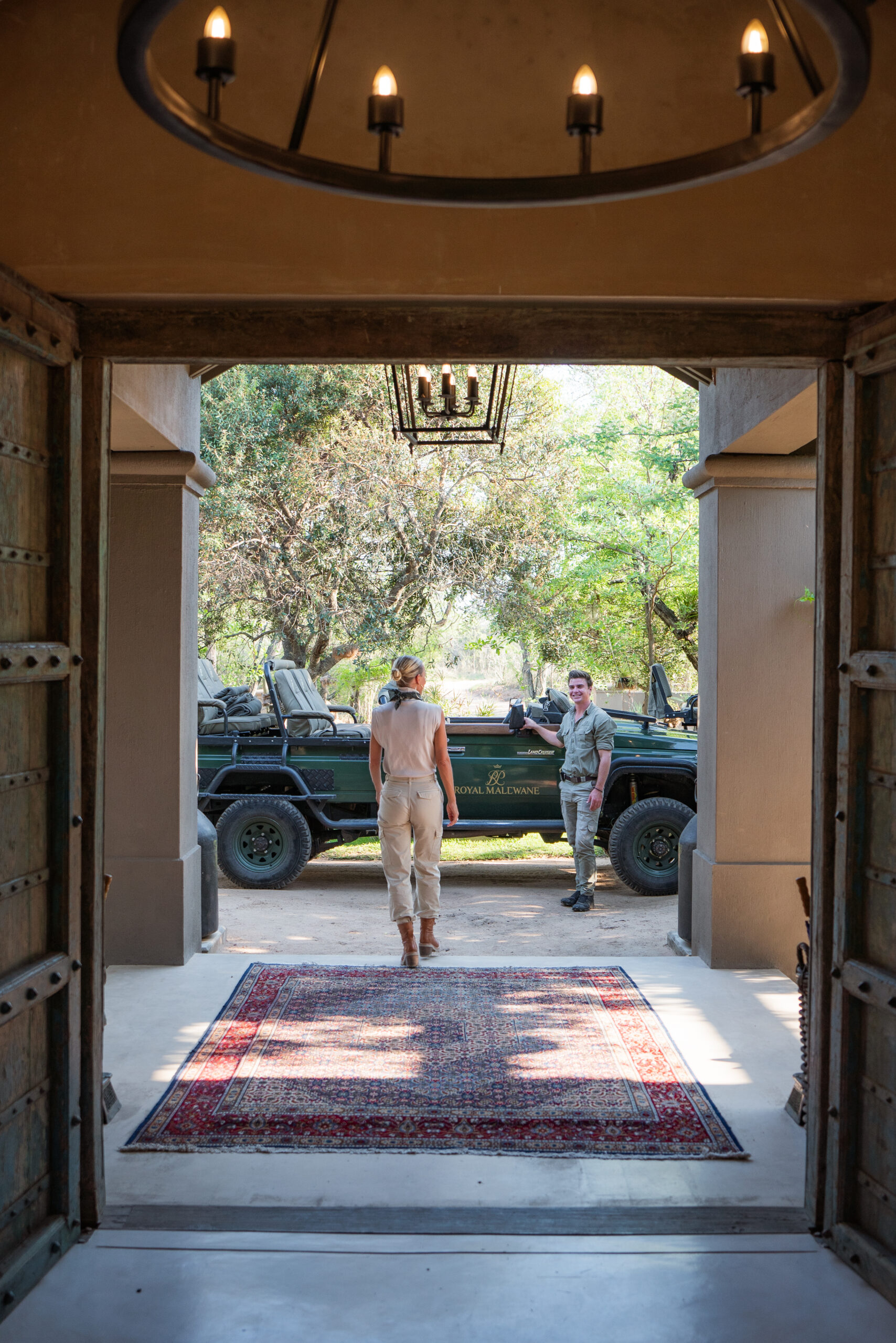 Salty Luxe walking out the entrance of Farmhouse at Farmstead to the Royal Malewane safari vehicle