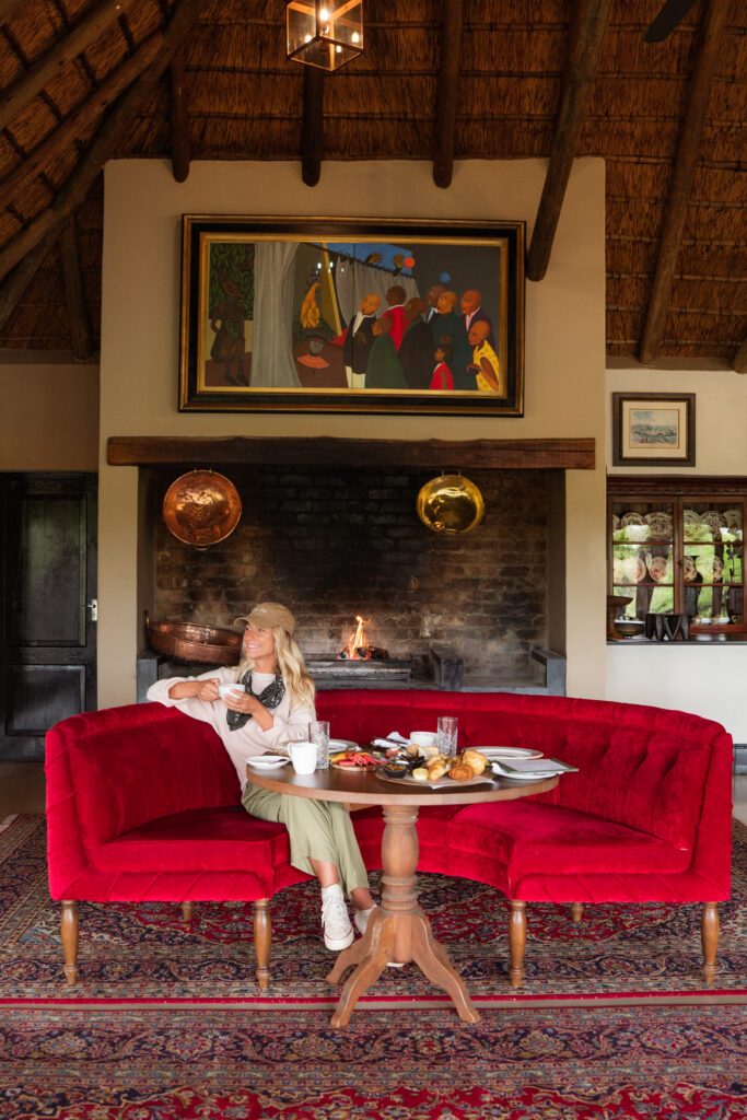 salty luxe sitting on a red couch inside malewane lodge