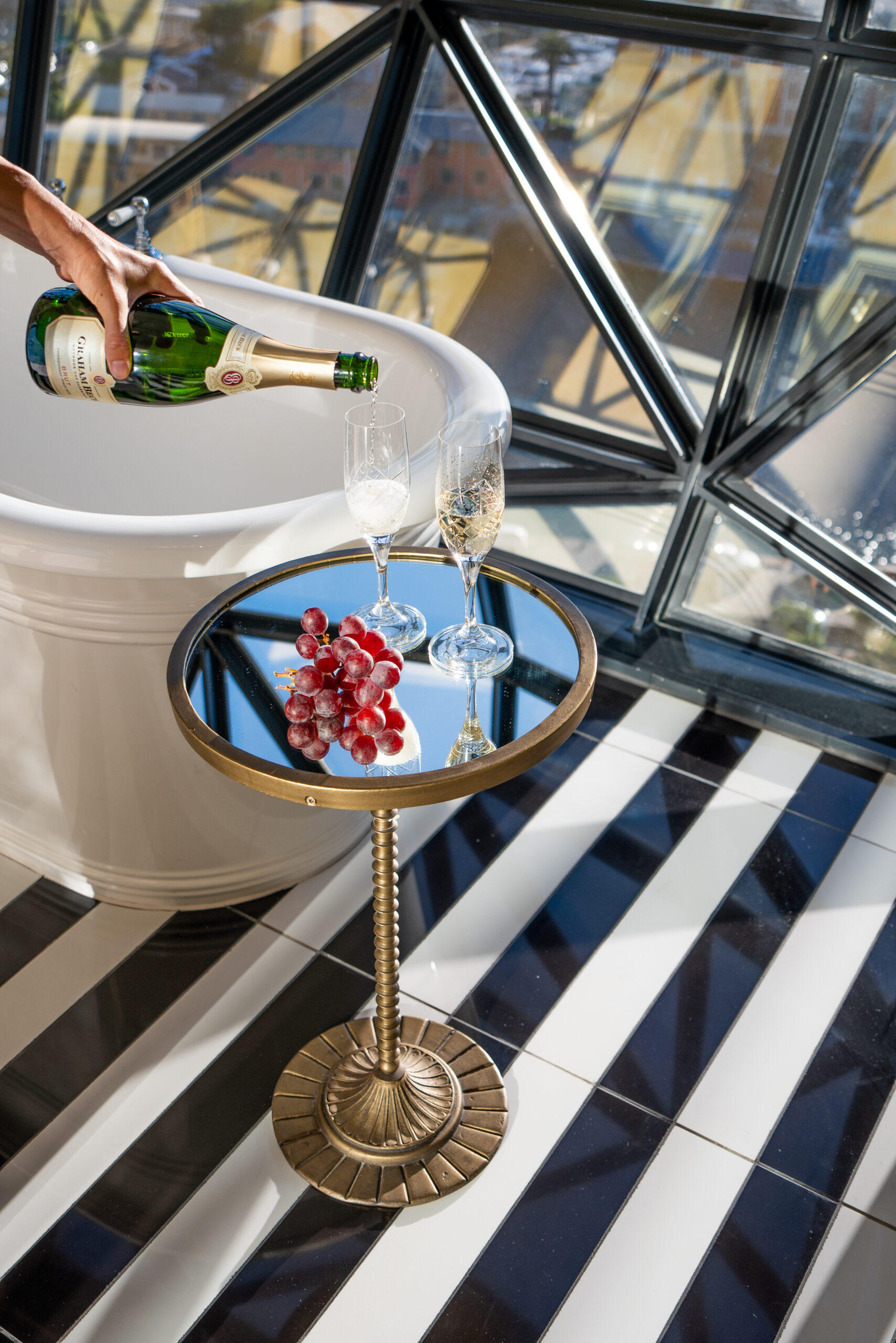 pouring a glass of champagne next to the bathtub at the silo hotel cape town