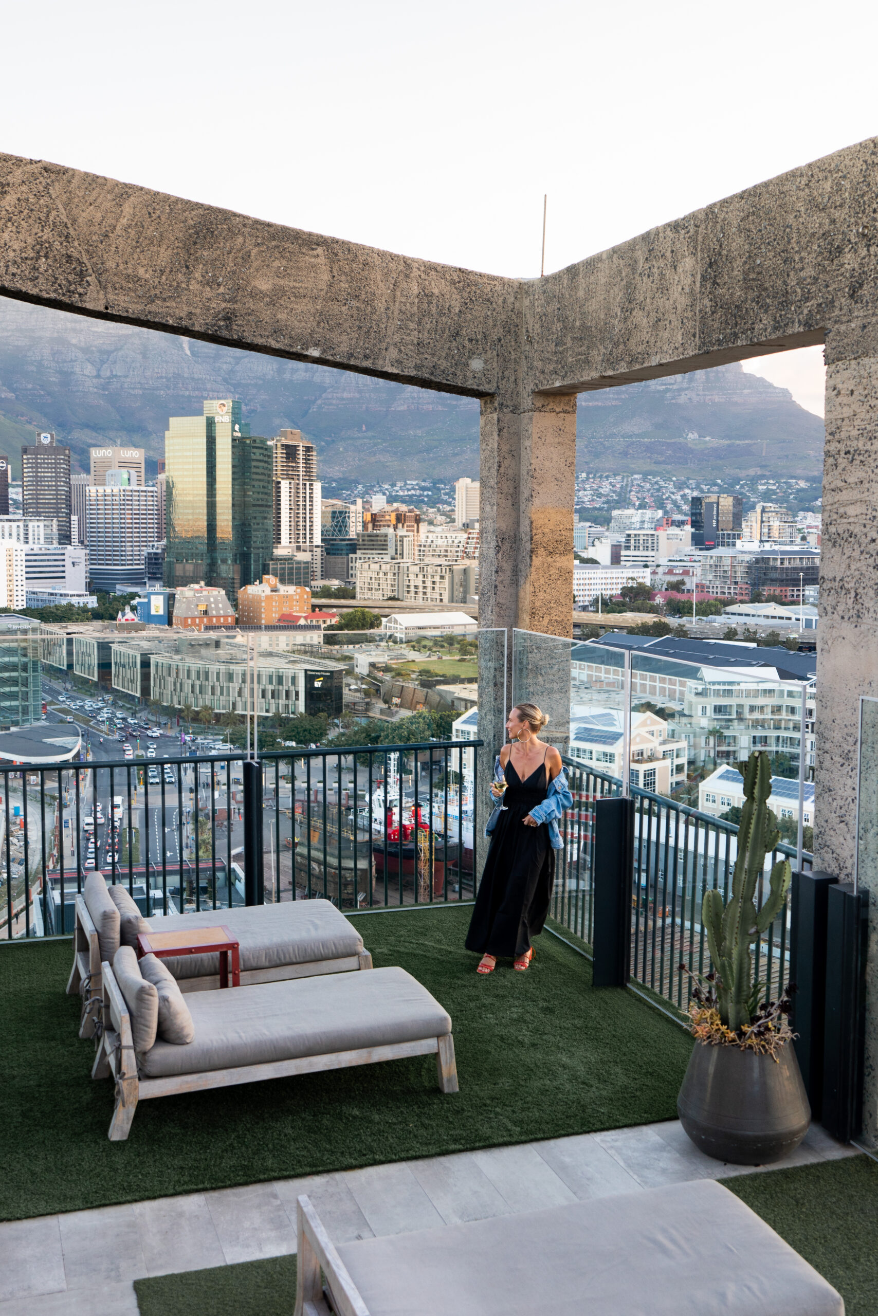 salty luxe on the rooftop deck at the silo hotel cape down with the city behind her