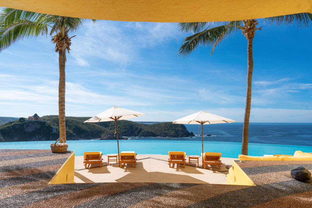 lounge chairs and view from pool at careyes resort mexico