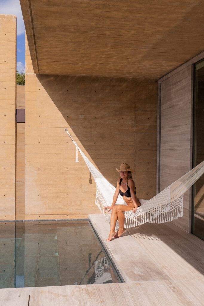 salty luxe sitting in a hammock at four seasons tamarindo in a cliffside private suite